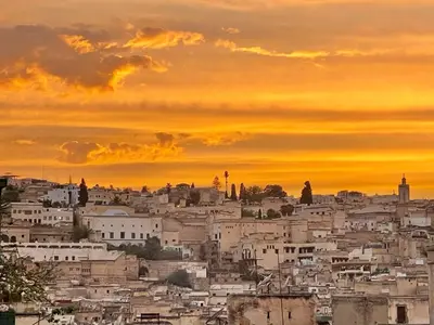 a city skyline with a sunset in the background at Rooms in Dar Drouj, a special 14th century house Riad in Fès