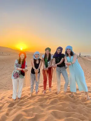 a group of women standing in the desert at Sahara Desert Camp in Merzouga