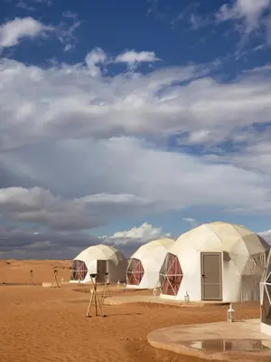 a group of three domes in the desert at Sahara Bubble in Merzouga