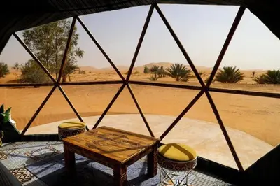 a view of a tent with a table and chairs at Sahara Bubble in Merzouga