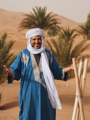 a man standing in the desert with his hand out at Sahara Bubble in Merzouga