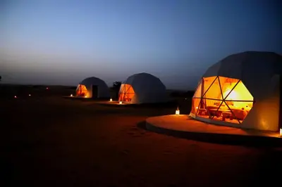 a group of tents in the desert at night at Sahara Bubble in Merzouga