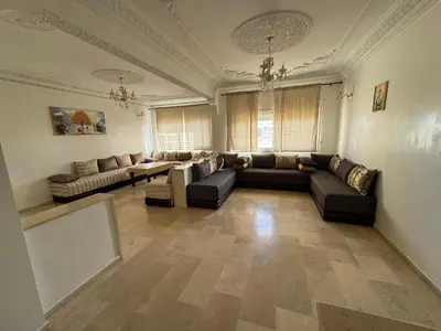 a large living room with couches and a table at Appartement 3 chambre et deux salon pour les familles in Fès