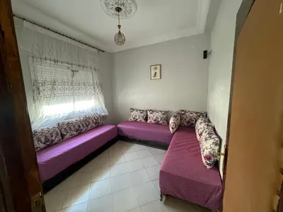 a living room with purple couches and a window at Appartement 3 chambre et deux salon pour les familles in Fès