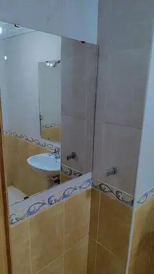 a bathroom with a sink and a mirror at Appartement 3 chambre et deux salon pour les familles in Fès