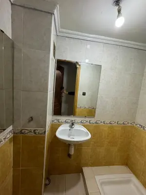 a bathroom with a sink and a mirror at Appartement 3 chambre et deux salon pour les familles in Fès