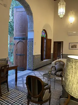 a living room with a chair and a table at Riad Hanael Garden & Spa in Fès