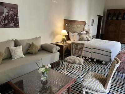 a living room with a couch and a bed at Riad Hanael Garden & Spa in Fès