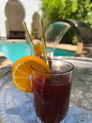 a drink on a glass plate with an orange slice at Riad Hanael Garden & Spa in Fès