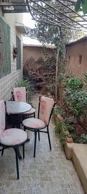 a patio with two chairs and a table and a table at Dar Fouzia in Bothmat