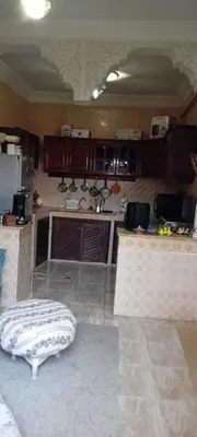 a kitchen with brown cabinets and a stool in a room at Dar Fouzia in Bothmat