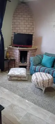 a living room with a couch and a flat screen tv at Dar Fouzia in Bothmat