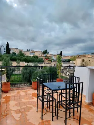 a patio with a table and chairs on a balcony at Dar Abdellah in Fès