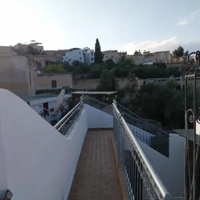 a bridge over a walkway with a city in the background at Dar Abdellah in Fès
