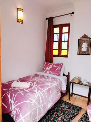 a bedroom with a bed and a window at Dar Abdellah in Fès