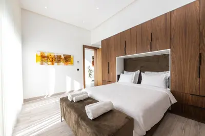 a bedroom with a large bed with a wooden wall at Villa Safira, Haut-Standing avec piscine & Hammam in Marrakech
