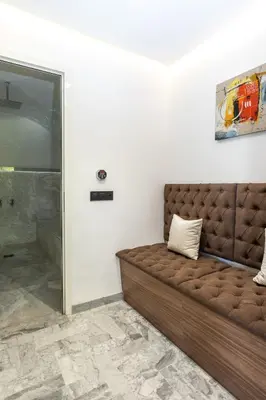 a brown couch in a room with a wall at Villa Safira, Haut-Standing avec piscine & Hammam in Marrakech