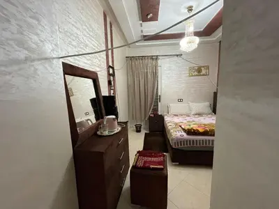 a bedroom with a bed and a dresser and a mirror at Mchimicha in Fès