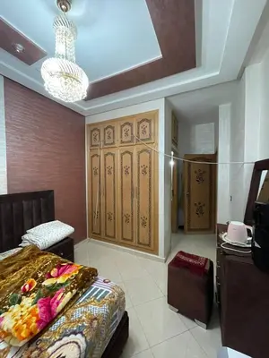 a bedroom with a bed and a chandelier at Mchimicha in Fès