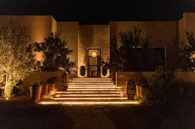 a building with stairs leading to a door at night at Villa A Atlas Retreat Luxury B and B Beni Mellal in Beni Mellal