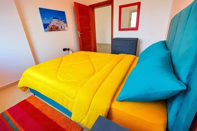 a bedroom with a bed with a yellow and blue comforter at Charming Two Bedroom Apartment in Fes Near City Center in Fès