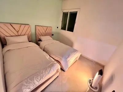 two beds in a small room with a window at Charming Two Bedroom Apartment in Fes Near City Center in Fès