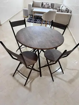 a wooden table and chairs in a living room at Charming Two Bedroom Apartment in Fes Near City Center in Fès