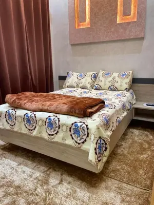 a bed with a blanket on it in a room at Location amine in Azrou