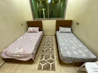 two beds in a small room with a mirror at Location amine in Azrou