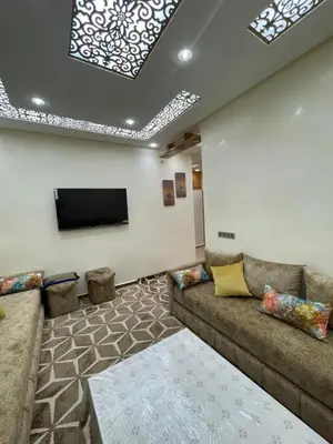 a living room with a couch and a flat screen tv at Location amine in Azrou