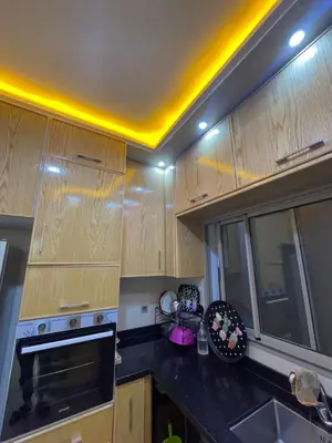 a kitchen with wooden cabinets and a black counter top at Location amine in Azrou