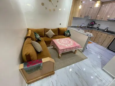 a living room with a brown couch and a table at Location amine in Azrou