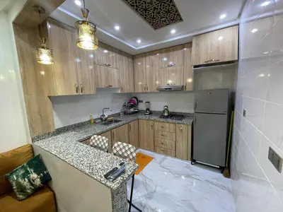 a kitchen with wooden cabinets and a counter top at Location amine in Azrou
