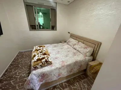 a small bedroom with a bed with a mirror at Location amine in Azrou
