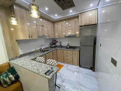 a kitchen with a counter and a sink and a refrigerator at Location amine in Azrou