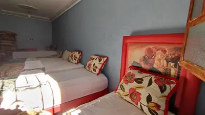 a bedroom with two beds and a painting on the wall at Dr ouanskra asni el haouz imlil in Imlil