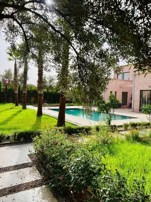 a swimming pool in a yard with trees and grass at Villa MK in Aghmat