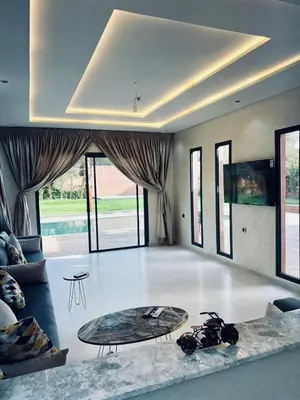 a living room with a table and a couch at Villa MK in Aghmat