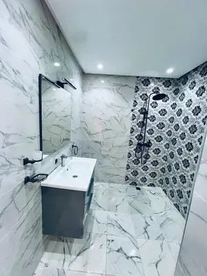 a white bathroom with a sink and a shower at Villa MK in Aghmat