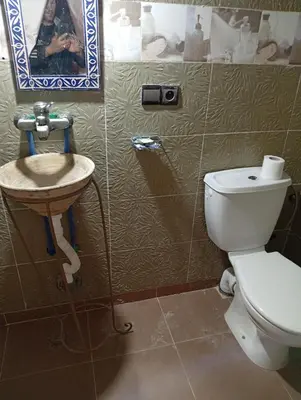 a bathroom with a toilet and a sink at Gite take your time takojt merzouga in Hassilabied