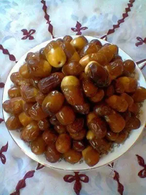 a bowl of olives on a plate on a table at Gite take your time takojt merzouga in Hassilabied