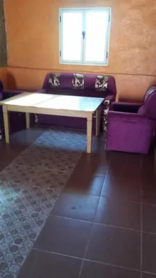 a bench sitting in a room with a window at Gite take your time takojt merzouga in Hassilabied