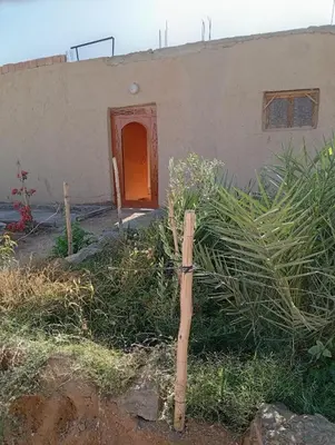 a wooden cross in front of a house at Gite take your time takojt merzouga in Hassilabied