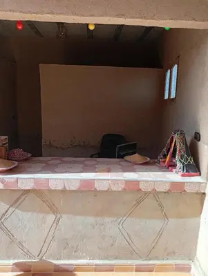 a room with a table and a chair in a room at Gite take your time takojt merzouga in Hassilabied