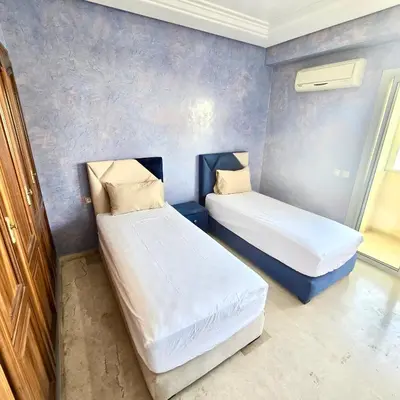 two beds in a room with blue walls at Luxueux appartement Assouan centre-ville in Fès