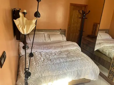 a bedroom with a bed and a lamp in it at Appartement hind in Azrou