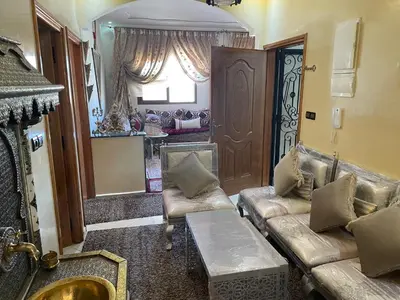 a living room with couches and a window and a door at Appartement hind in Azrou