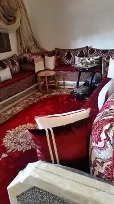 a living room with a couch and a red carpet at Appartement hind in Azrou