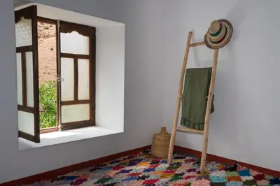 a room with a ladder and a rug and a window at Auberge Sremt in Sremt