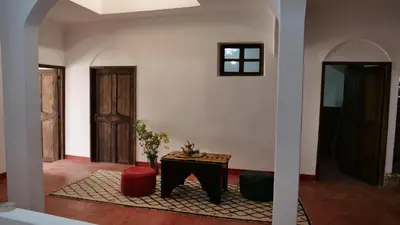 a living room with a table and two doors at Auberge Sremt in Sremt